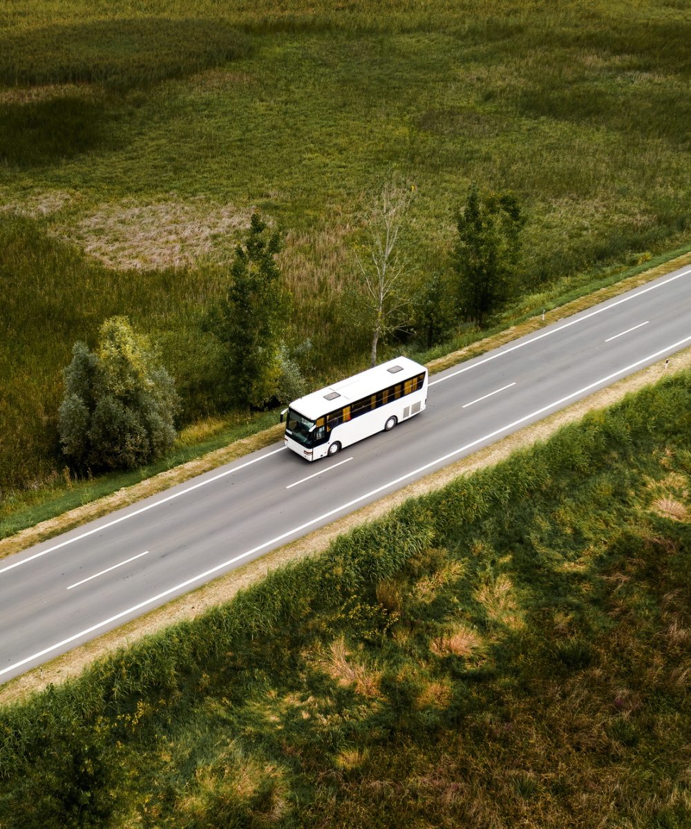 Aerial view of passenger bus on road through countryside